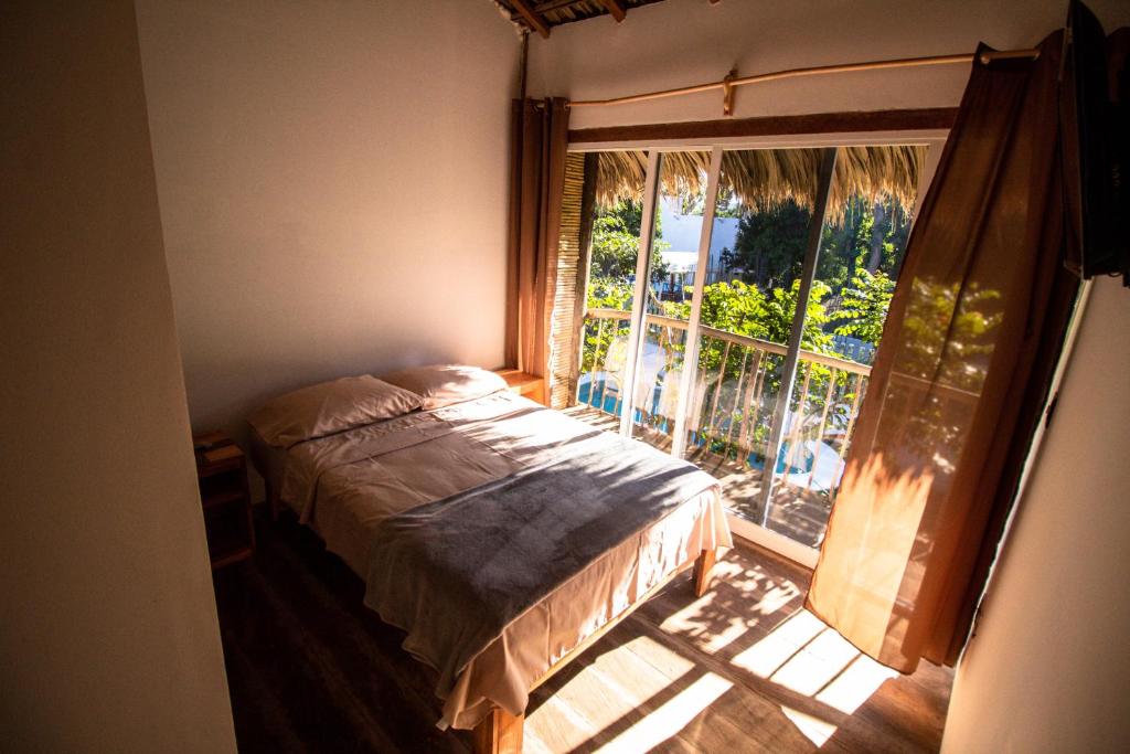 阿卡普尔科Kali Village的卧室在窗户前配有一张床