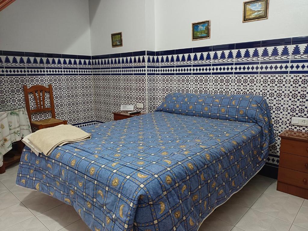 迈雷纳-德尔阿尔科PENSIÓN LARRA的一间卧室配有蓝色的床和椅子