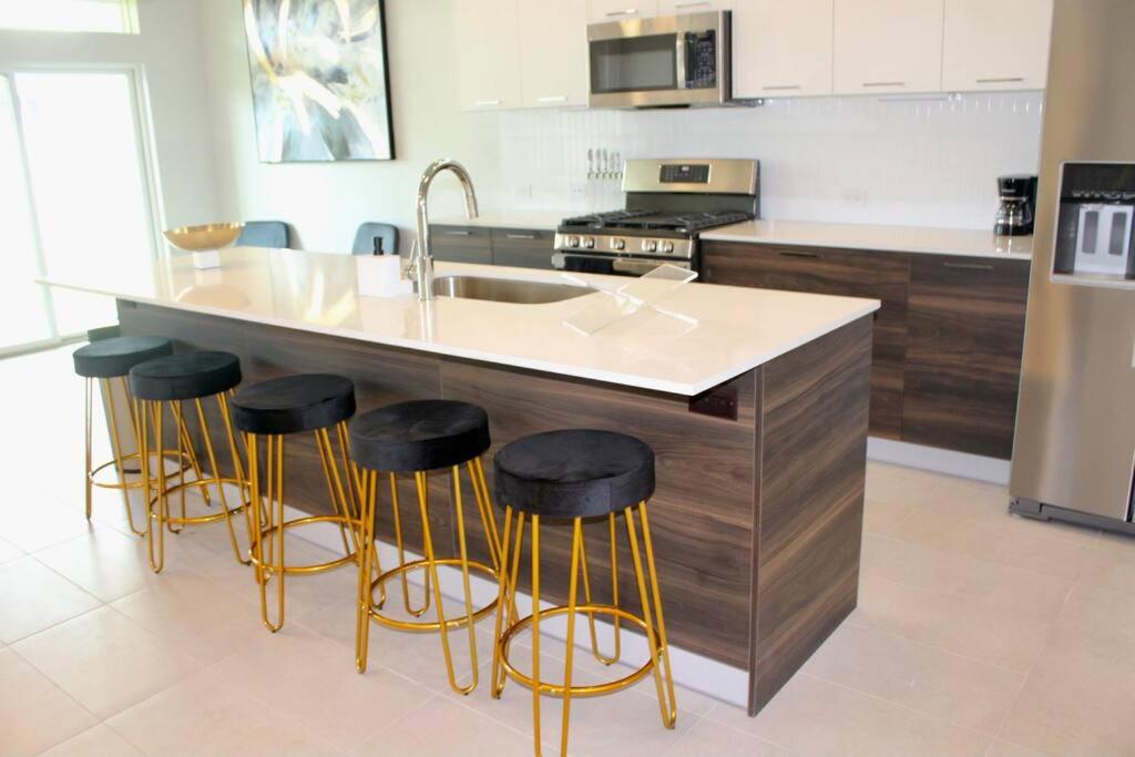 休斯顿Modern Minimalist Luxury Retreat的厨房配有水槽和酒吧凳