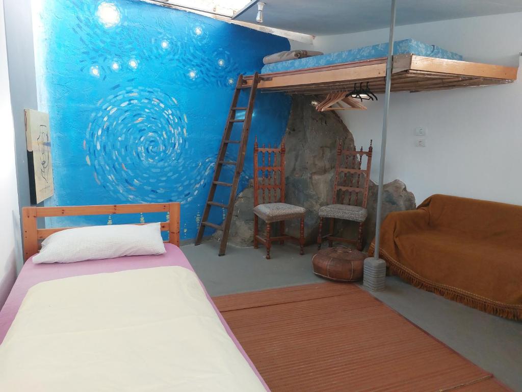 蒂约那Twin room in the greenhouse close to mountains and surf paradise的一间卧室配有双层床和沙发