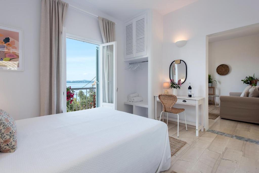 巴尔巴蒂Reana Elegant Apartments的白色的卧室设有床、书桌和窗户