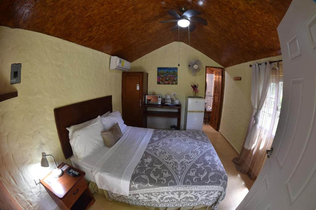 埃尔巴列德安通维拉维多利亚山林小屋的一间卧室配有一张床和吊扇