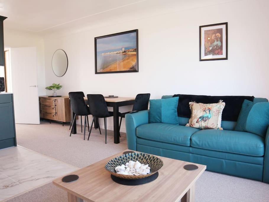 KentOcean View apartment, beautiful sea views的客厅配有蓝色的沙发和桌子