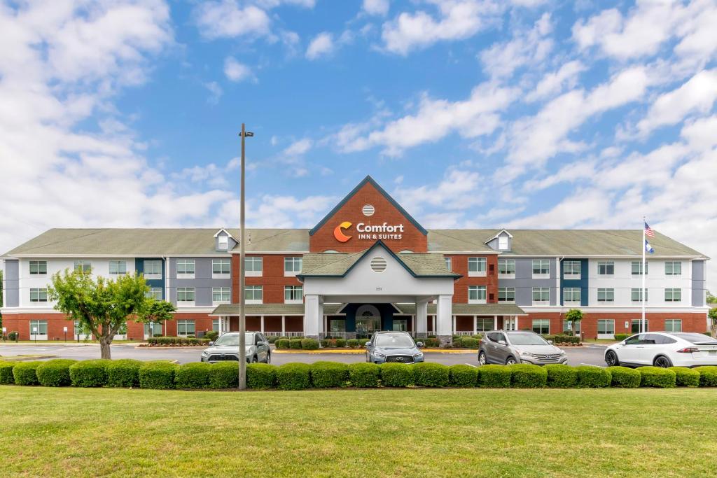 汉普顿Comfort Inn & Suites Hampton near Coliseum的停车场内停放汽车的大型建筑