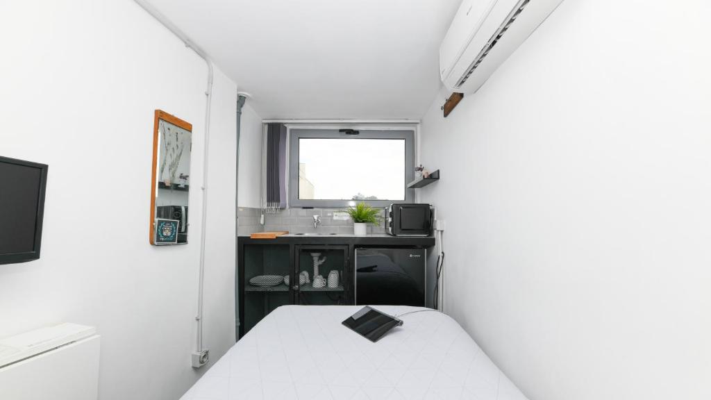 雅典Monastiraki City Sleepbox- Unspoiled Athens Apartments的一间白色的小房间,配有床和水槽