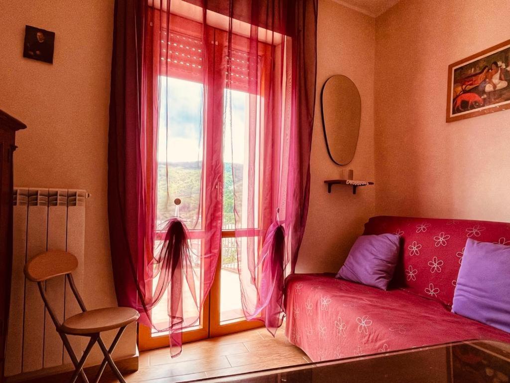 CastelsaracenoLa Casa dei Panorami的客厅设有红色的沙发和窗户。