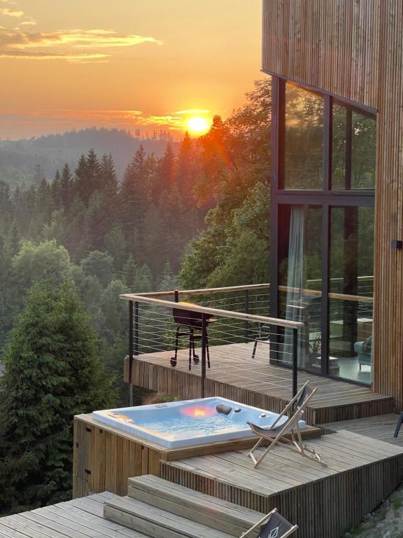 布伦纳Widokownia Brenna的一座房子,在甲板上设有小型游泳池,享有日落美景