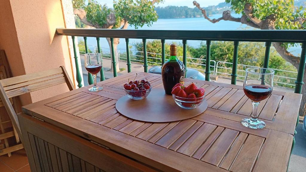 米尼奥SALSEIRAZO - PLAYA A RIBEIRA MIÑO的一张桌子,上面放着一瓶葡萄酒和两杯酒