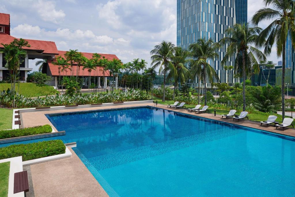 普特拉贾亚棕榈花园度假酒店的一座带椅子的大型游泳池和一座建筑