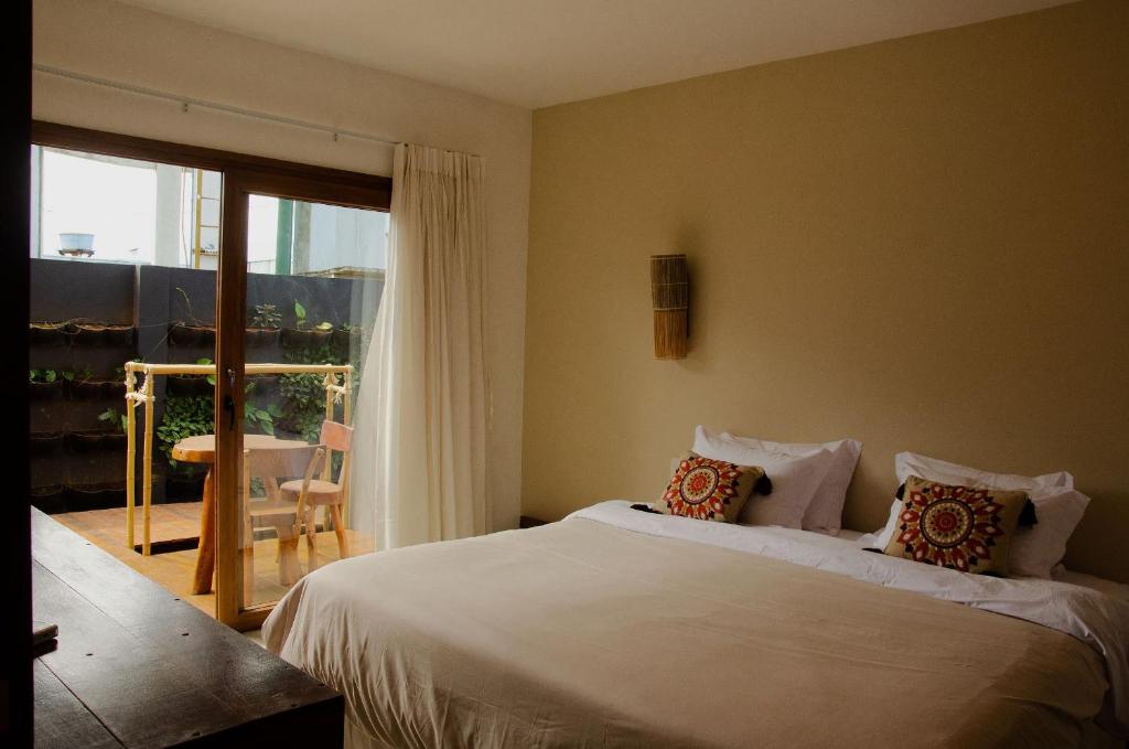 费尔南多 - 迪诺罗尼亚Casa Makaira的一间卧室设有一张床和一个滑动玻璃门