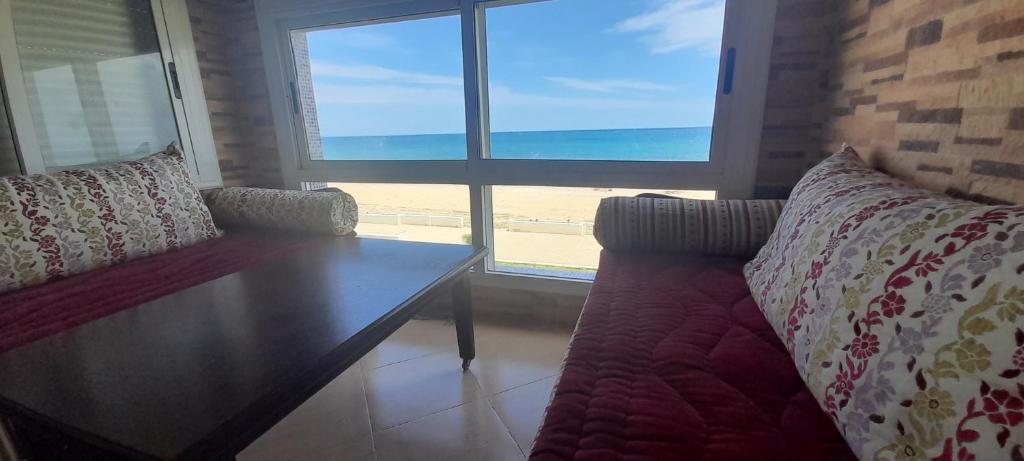 弗尼迪克Résidence Al Amine Plage accès direct à la plage的带沙发的客厅,享有海滩美景