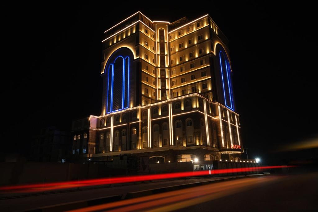 巴士拉Move npic Zenat al Hayat Hotel的一座大建筑,晚上有蓝色的灯光