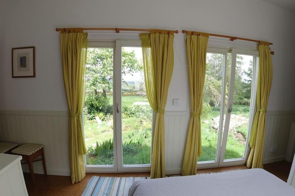 斯莱戈Innisfreedom cabin的一间卧室设有大窗户,配有黄色窗帘
