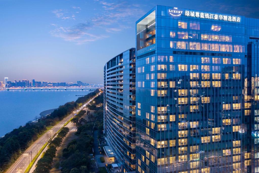 杭州杭州绿城尊蓝钱江豪华精选酒店的水边高蓝色建筑的空中景观