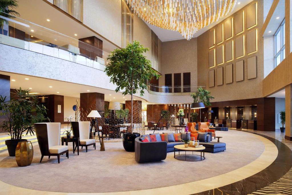 萨姆松萨姆松喜来登大酒店的酒店大堂设有长沙发、椅子和吊灯。