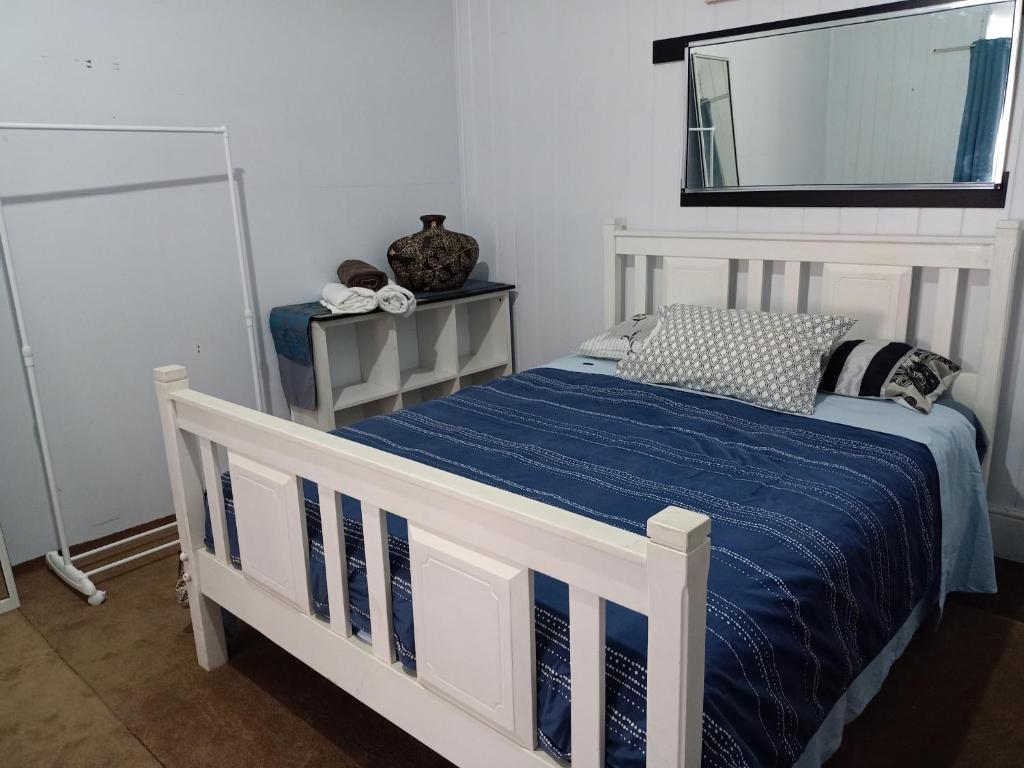 汤斯维尔Spacious Suite的一张带蓝色棉被和镜子的白色床