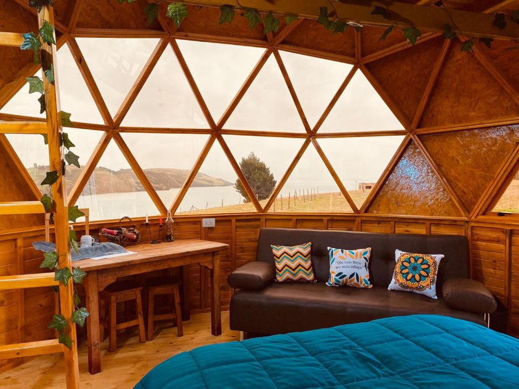 托塔Lago De Tota Glamping的一间配有沙发和窗户的冰屋客房