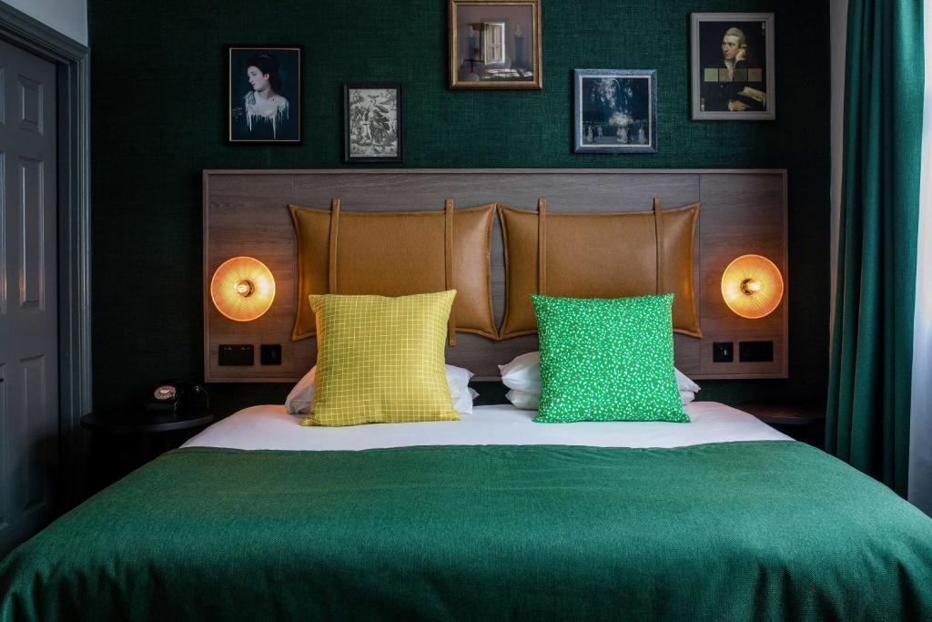 巴斯Abbey Hotel Bath, a Tribute Portfolio Hotel的一间卧室配有一张带绿色和黄色枕头的床