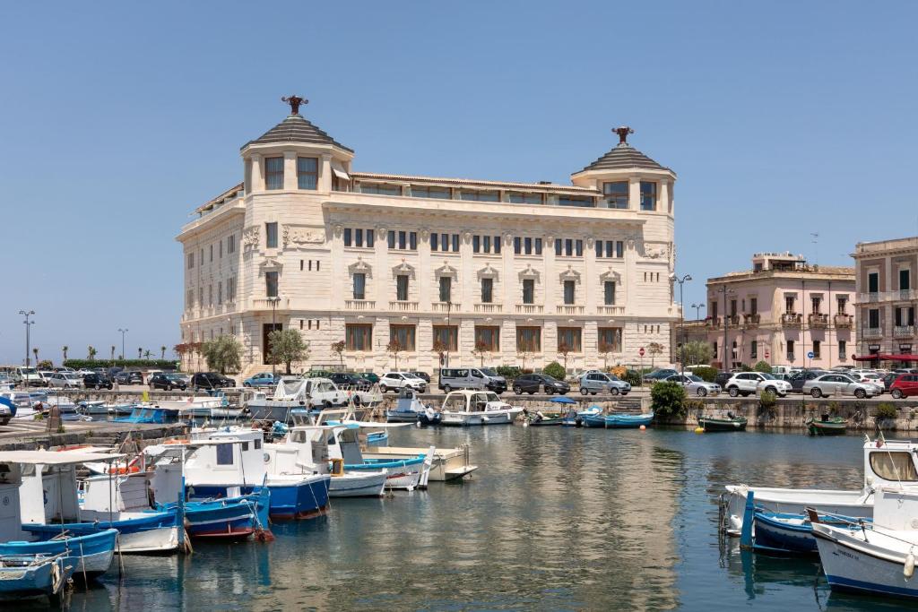 锡拉库扎Ortea Palace Hotel, Sicily, Autograph Collection的一群船在建筑物前的码头