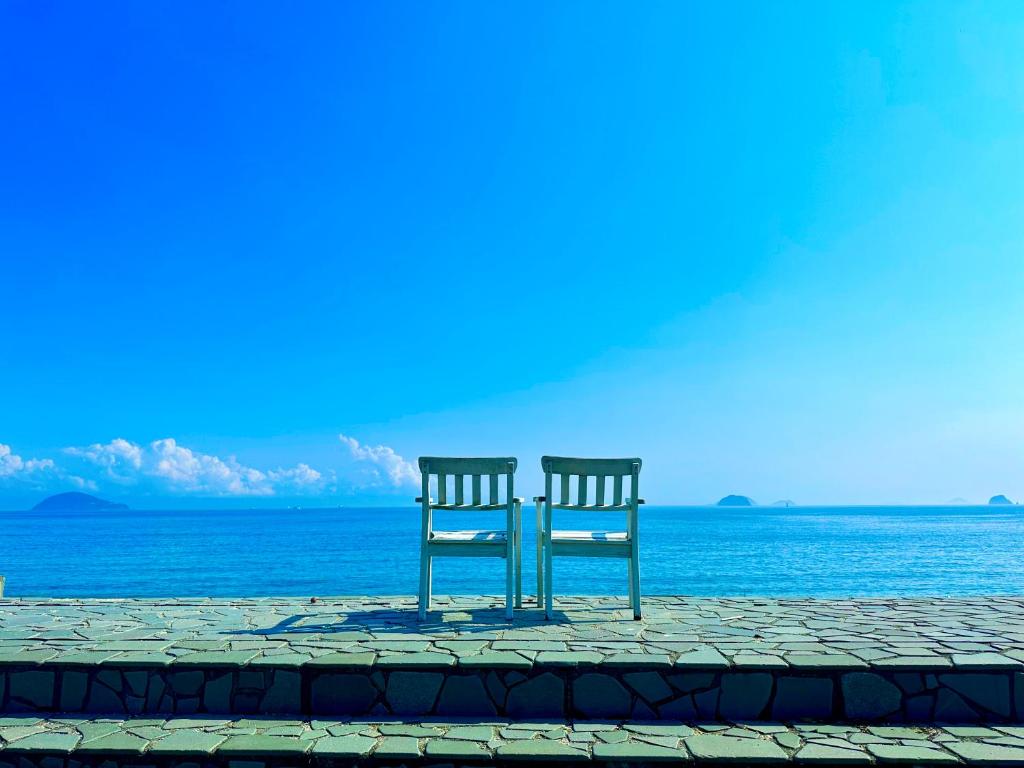 松山なにもない幸せな島のリトリート宿 The Bonds的两把椅子坐在海边