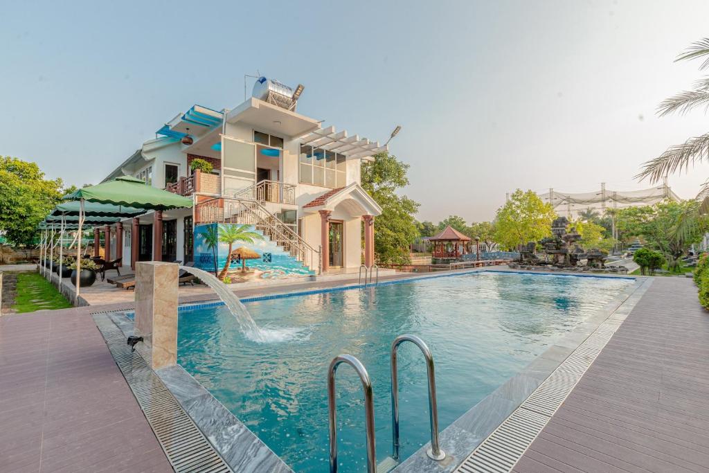 宁平Hoa Lu Garden Resort的房屋前带水滑梯的游泳池