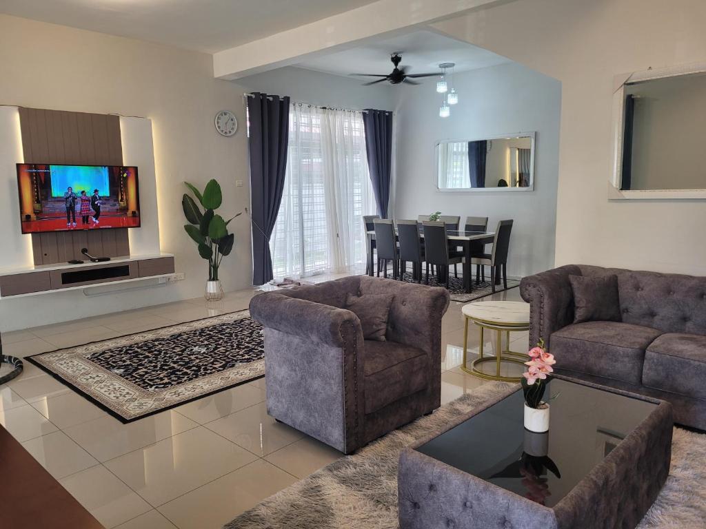 马六甲Ana Homestay D'Airport的客厅配有两张沙发和一台电视机