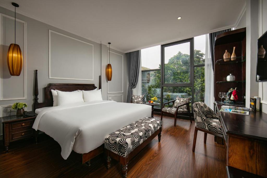 河内Salute Premium Hotel & Spa的卧室配有一张白色大床和一张书桌