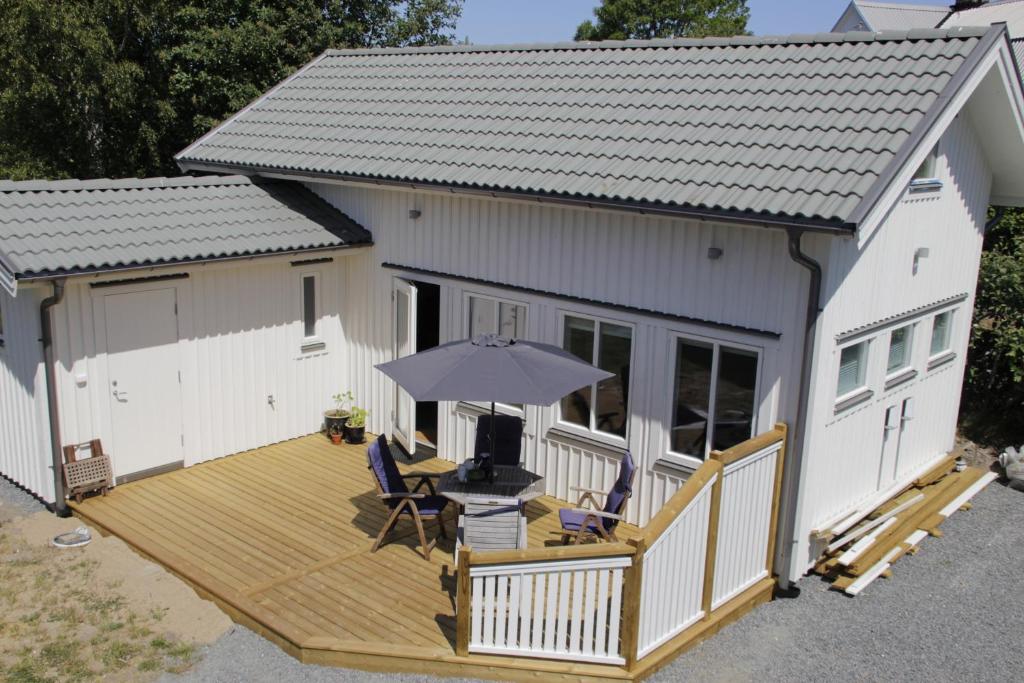 瓦尔贝里Fräsch nybyggd stuga på Getterön Varberg的一座带遮阳伞的木甲板的房子