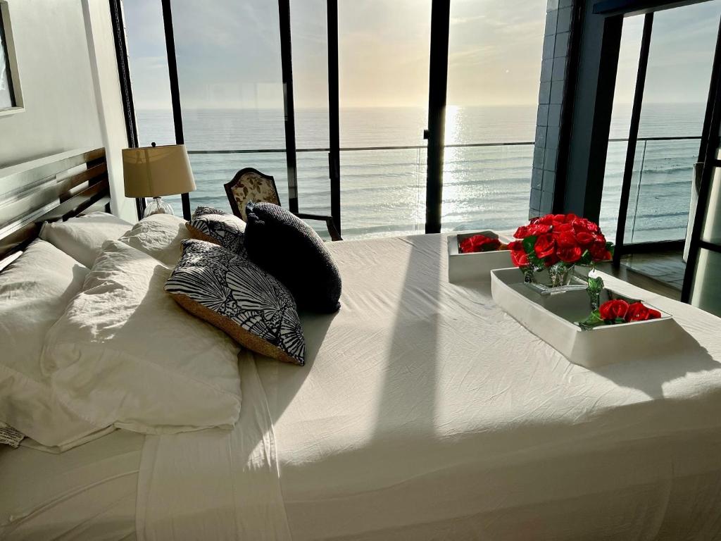圣地亚哥Ocean View Luxury Condo Oceanfront and Pool的窗户客房内的一张大白色床
