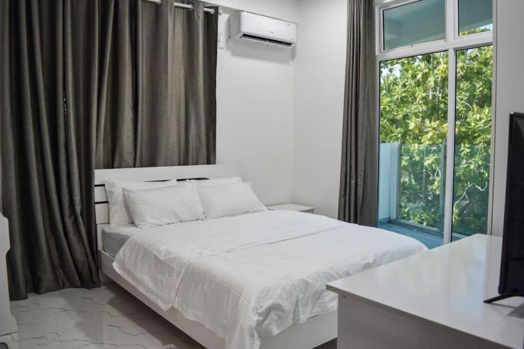 FuvahmulahEQUATOR RETREAT的卧室配有白色的床和窗户。