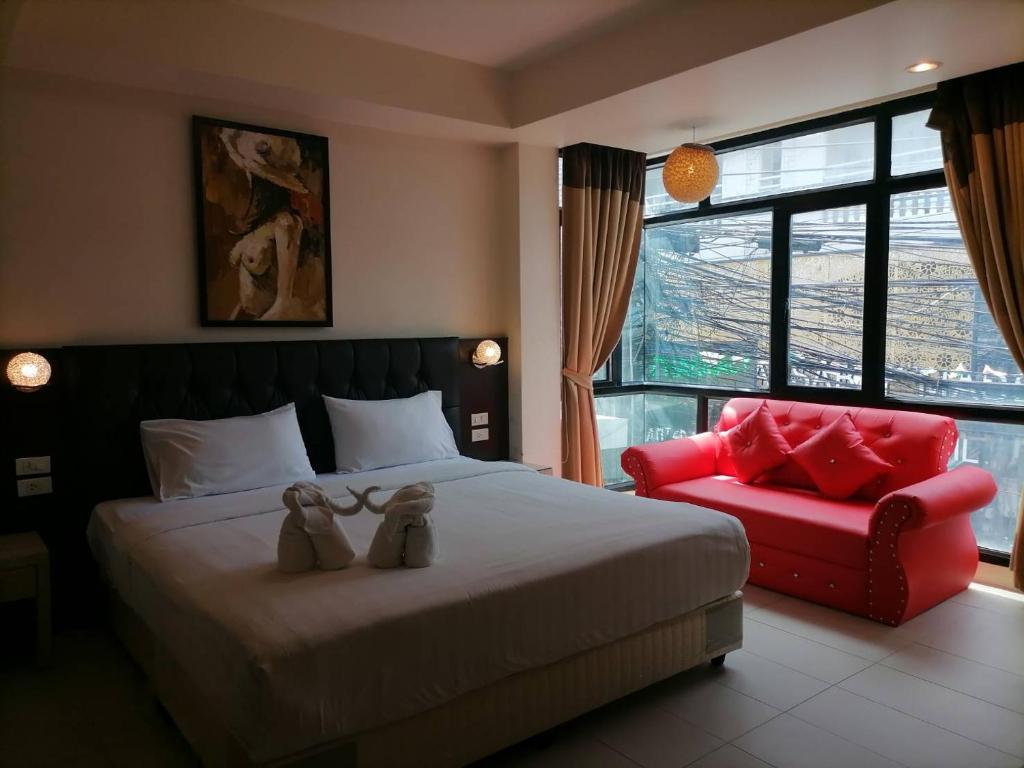 芭东海滩Amici Miei Guest House的一间卧室配有一张床和一张红色椅子