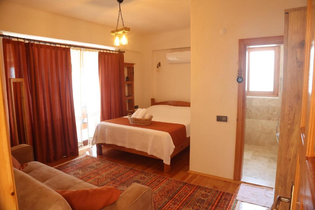 安塔利亚Istlada Taş Ev Apart - Kekova View的一间卧室配有一张床、一张沙发和一个窗口