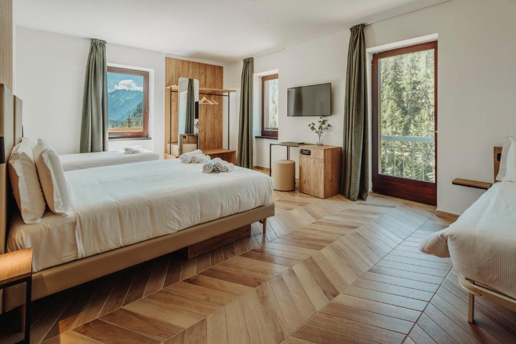科尔蒂纳丹佩佐B&B Hotel Passo Tre Croci Cortina的一间卧室配有一张大床和电视