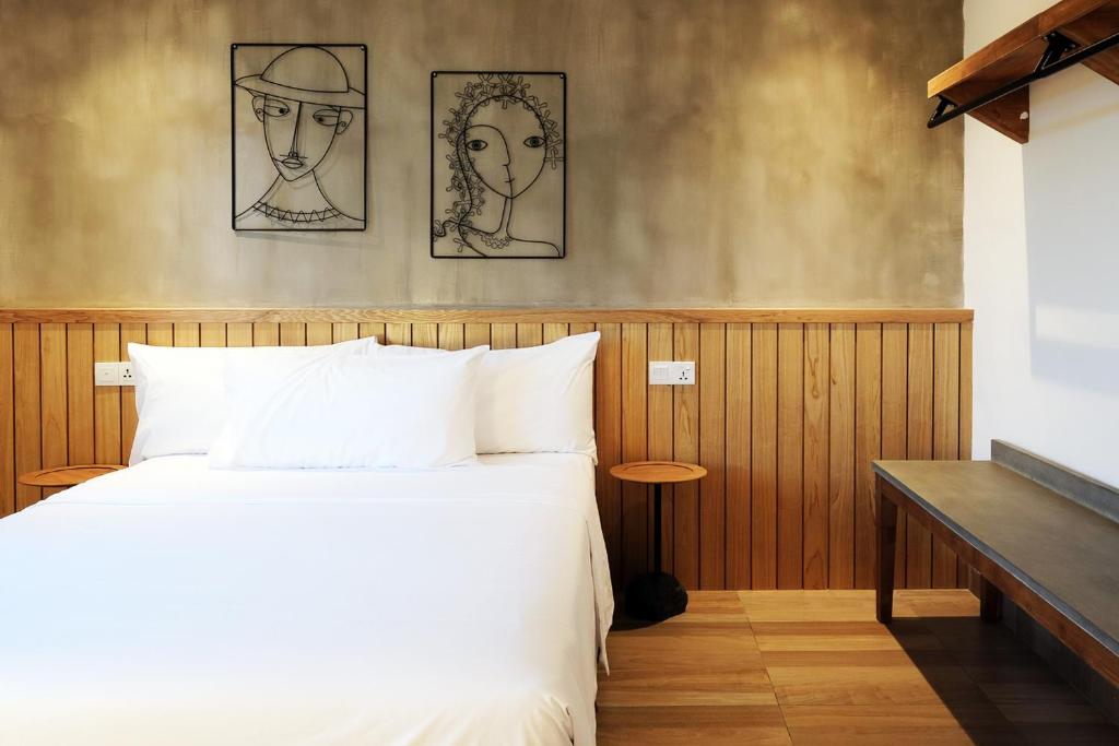 珍南海滩The Bayou Hotel Langkawi的卧室配有一张床,墙上有两张画