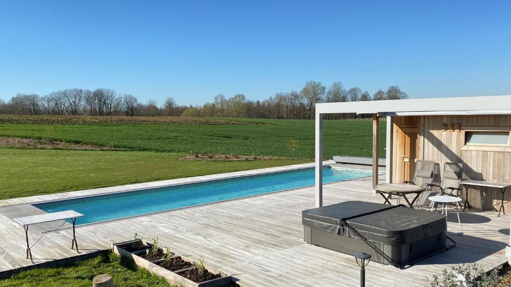 Villers-la-VilleB&B Les Autres Sens的一个带游泳池和房子的后院