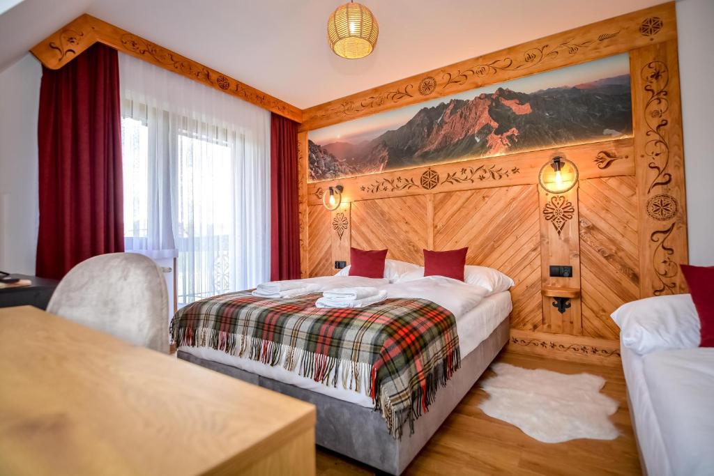斯扎法拉瑞Cicha Woda 300 m od Gorący Potok i Termy Szaflary的酒店客房设有一张床,墙上挂有绘画作品