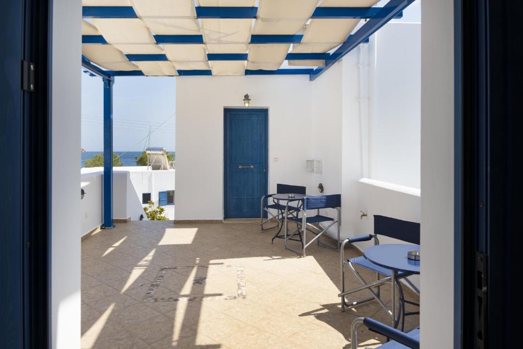 利瓦迪奥Studios Ninemia Serifos 5的客房设有桌椅和蓝色天花板。