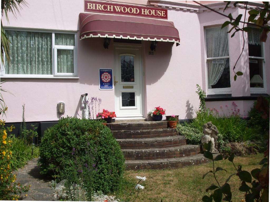 佩恩顿Birchwood House的粉红色的房子前面设有楼梯