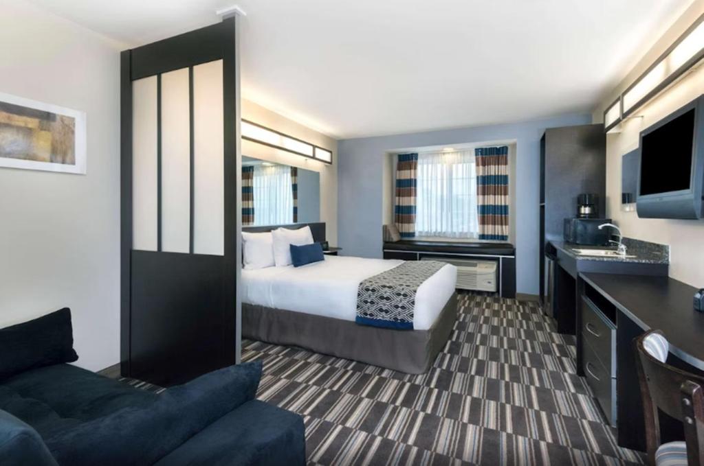 巴吞鲁日巴敦罗吉机场麦克罗特套房酒店的酒店客房,配有床和沙发