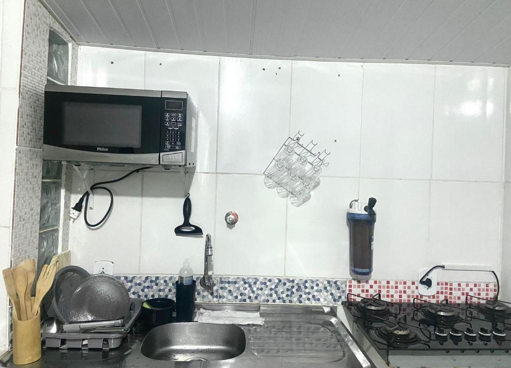 马卡埃Casa top aeroporto的厨房配有水槽和微波炉