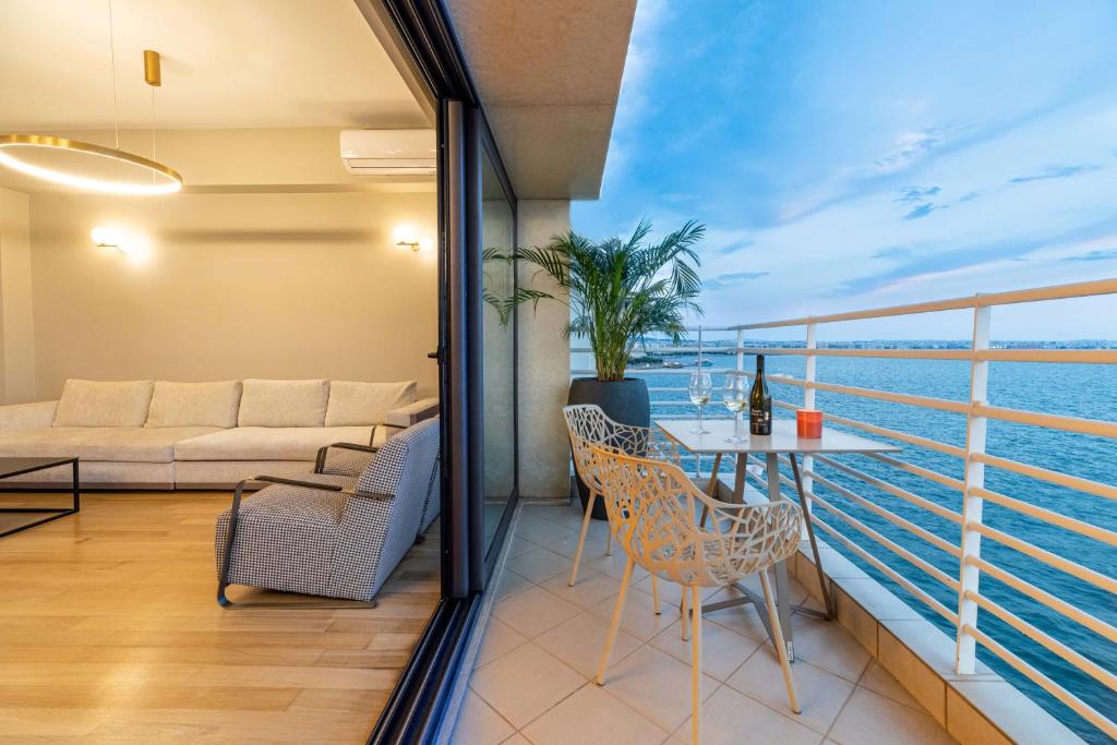 塞萨洛尼基ICONIC SALONICA SUITE seafront的客房设有带桌椅的阳台。