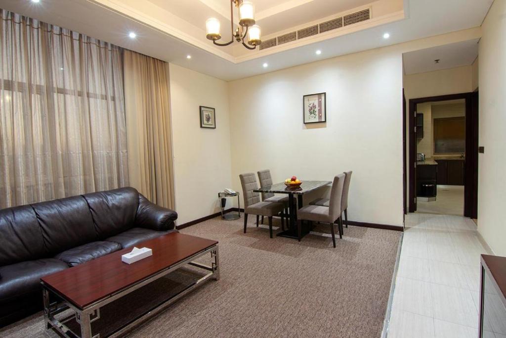 迪拜Better Living Apartment的客厅配有真皮沙发和桌子