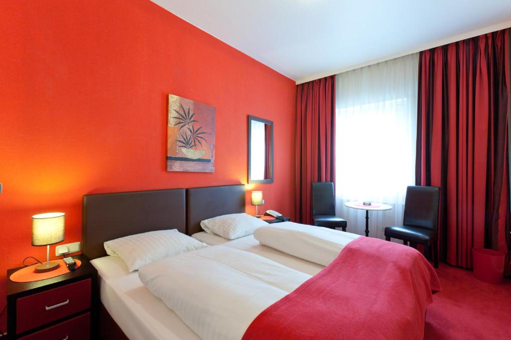 汉堡帝国酒店的一间卧室配有一张带橙色墙壁的大床