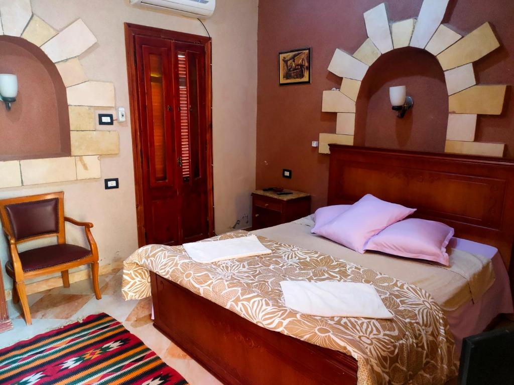 锡瓦Panta Lodge Siwa بنتا لودج سيوة的一间卧室配有一张带椅子和镜子的床