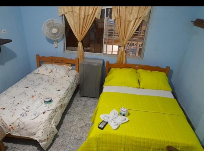 莱蒂西亚Hospedaje Mirador Grecia的一间卧室配有一张黄色的床,床上有鲜花