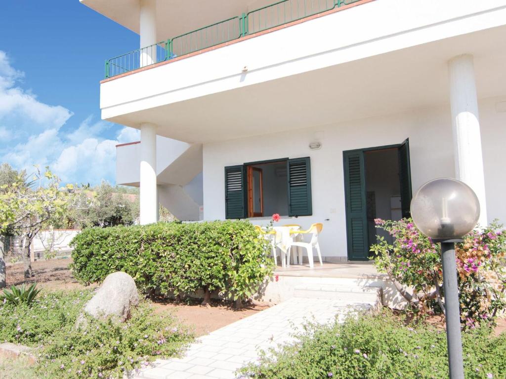 里卡迪Nice residence in San Nicol di Ricadi with pool的白色的房子,设有绿色百叶窗和庭院