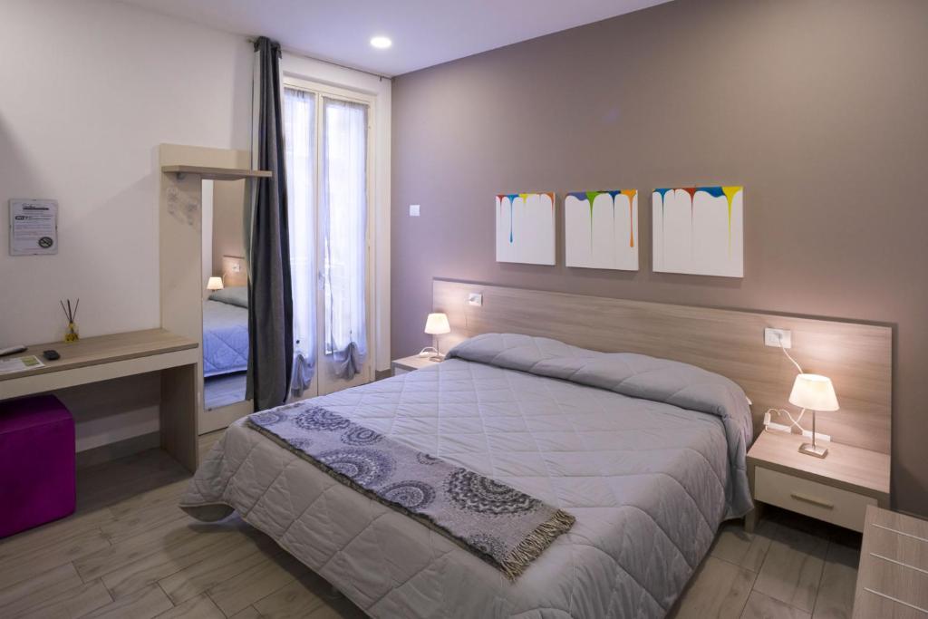 诺瓦拉Ventitrémarzo Guest House的一间卧室配有一张大床和镜子
