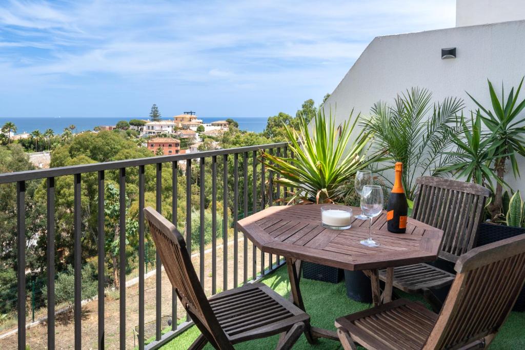 米哈斯科斯塔Lets in the Sun Casa del Cielo Apartment的阳台上的桌椅和一瓶葡萄酒