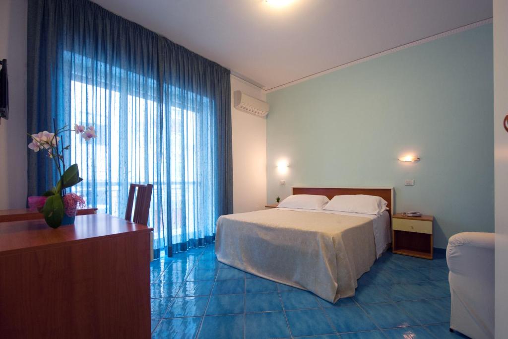 马奥莱奥西酒店的酒店客房设有一张床和一个大窗户