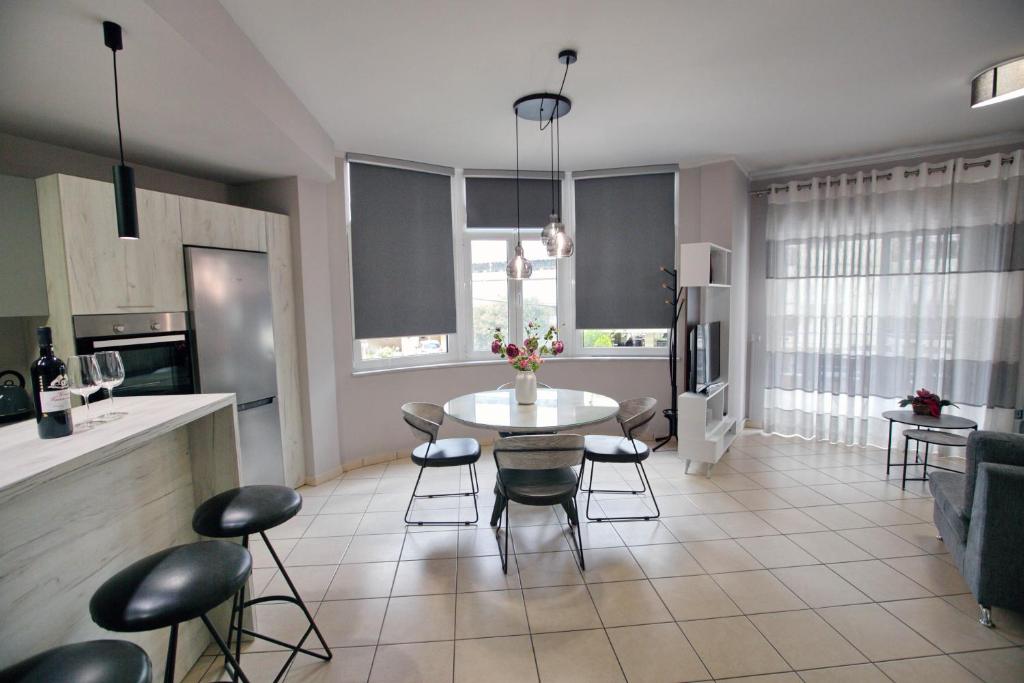 纳夫普利翁Ioanna's Luxury Two Bedroom Apartment的厨房以及带桌椅的起居室。